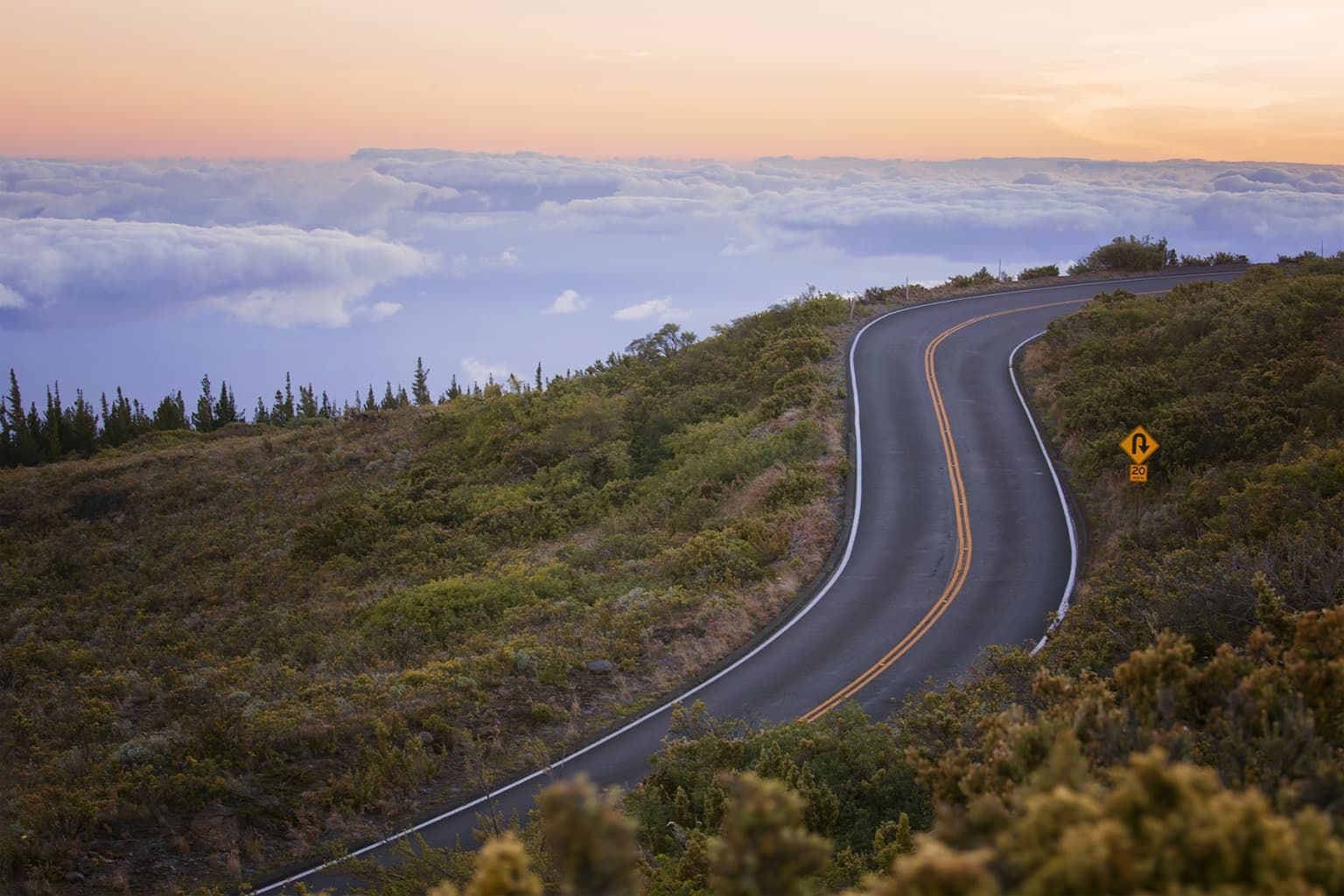 Mountain road winding into the distance at sunrise
